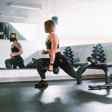 Athlète s'entraînant dans une salle de sport à domicile moderne et bien équipée, illustrant un espace fitness intérieur