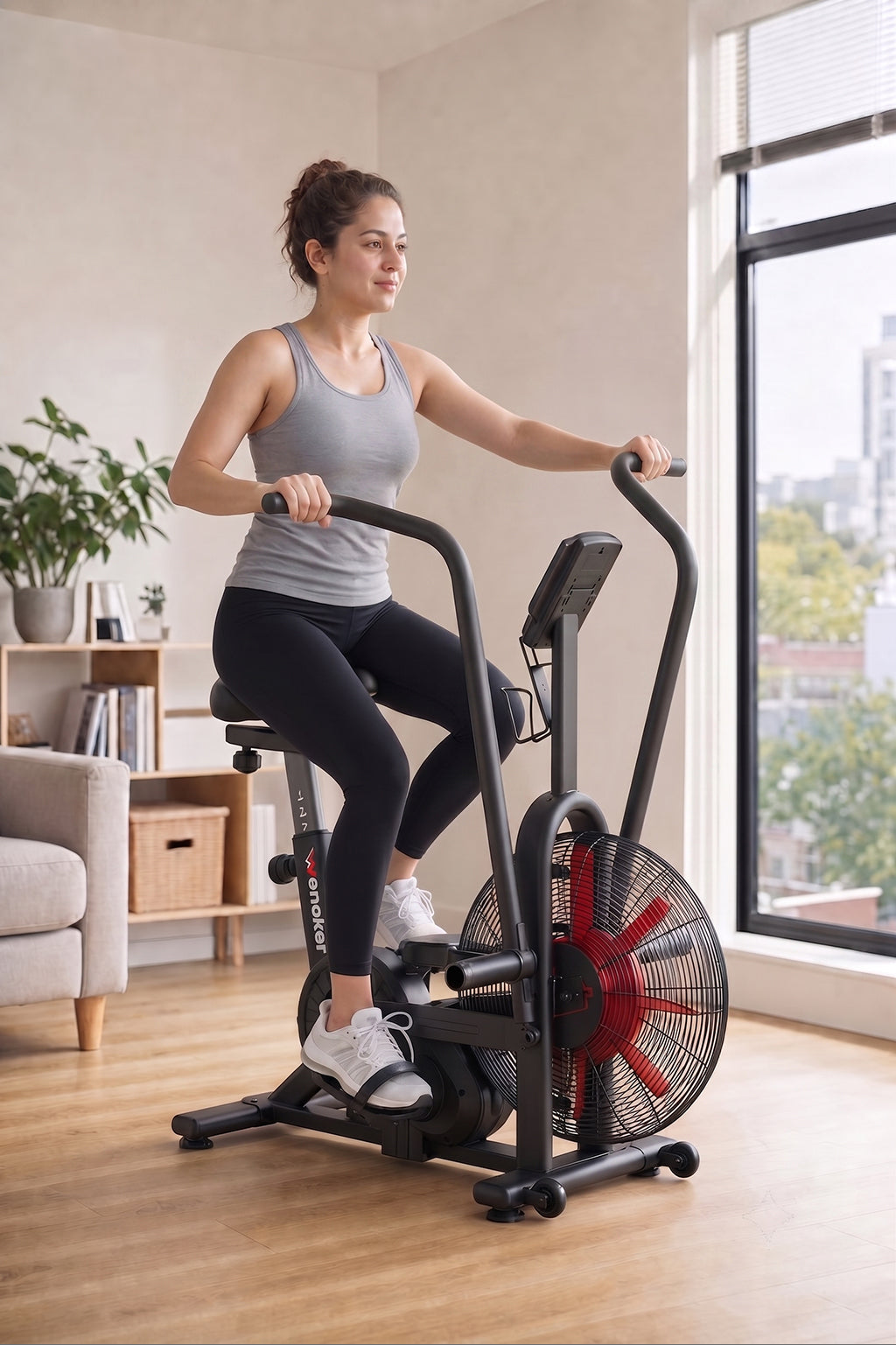 Femme sur un air bike dual-action Wenoker K29650 près d’une fenêtre d’appartement lumineuse
