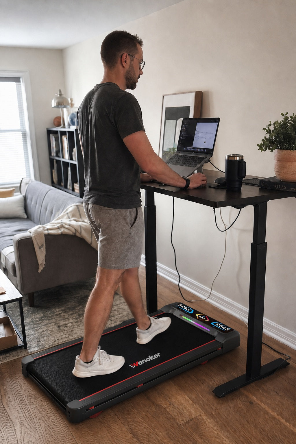 Homme utilisant le tapis de marche incliné Wenoker A8 près d’un bureau assis-debout à domicile